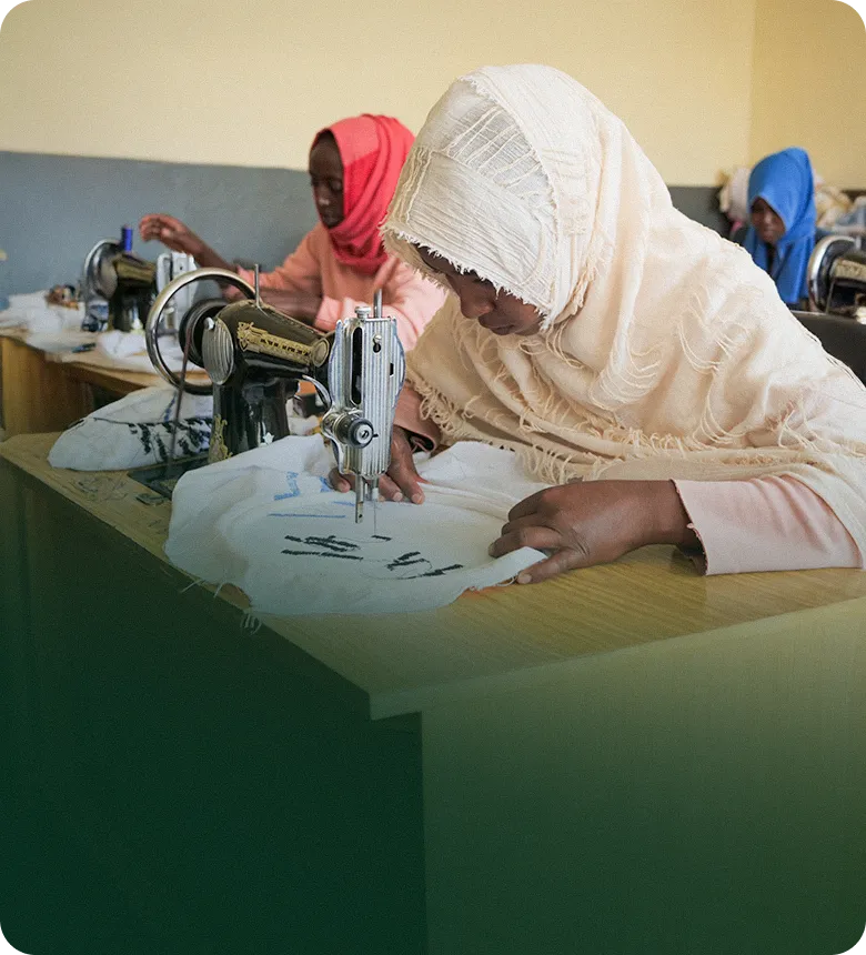 머리스카프를 쓴 여성들이 재봉틀 작업하는 모습