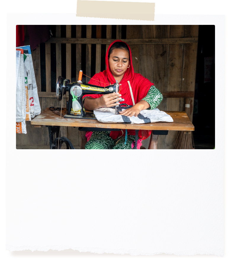 머리에 빨간 스카프를 두른 여성이 재봉틀하는 모습