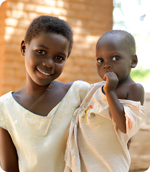 어린 동생을 안고 미소 짓는 소녀